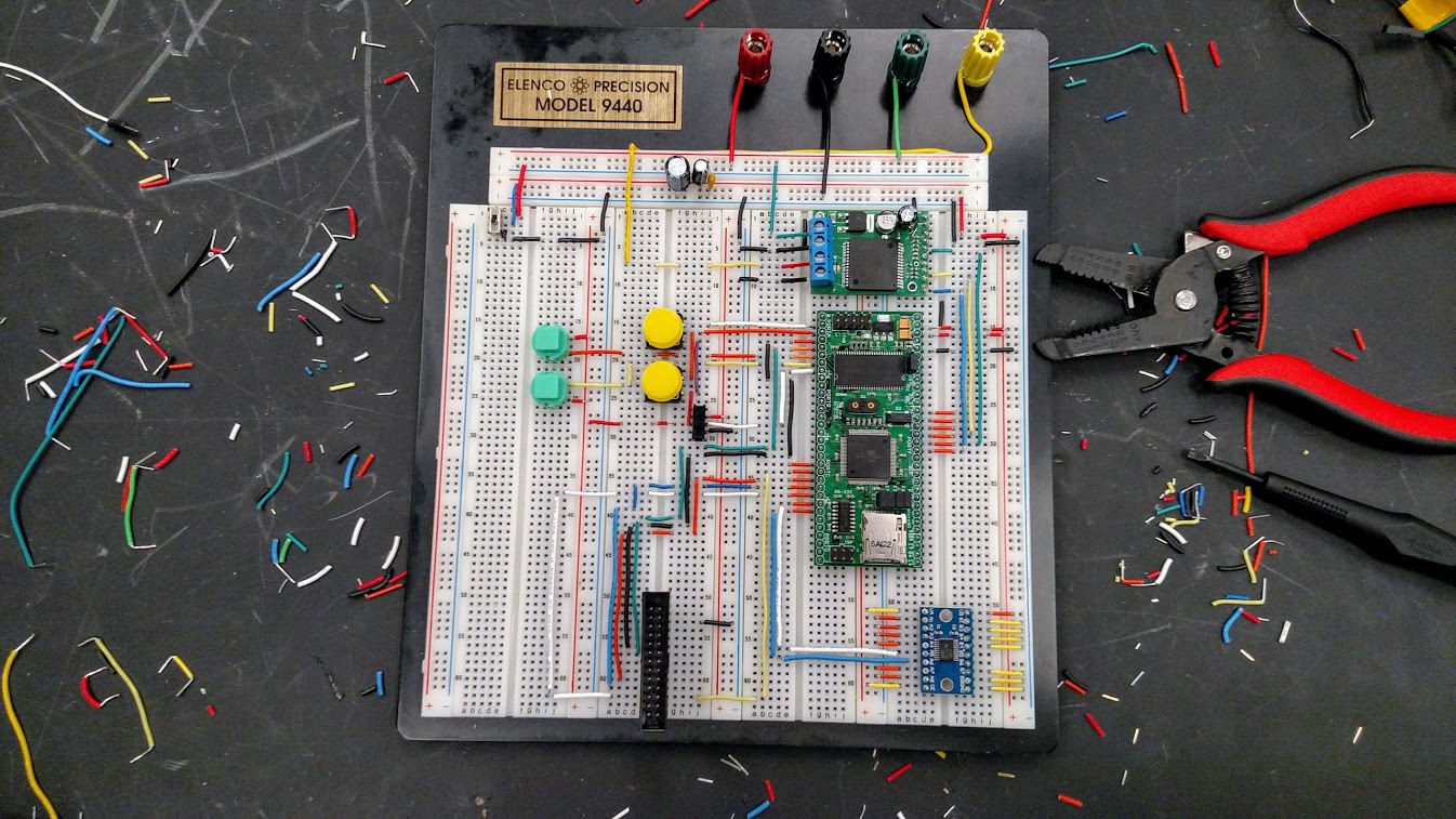 prototyping a microcontroller on a breadboard. Random bits of wires can be seen around the black table.