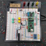 prototyping a microcontroller on a breadboard. Random bits of wires can be seen around the black table.